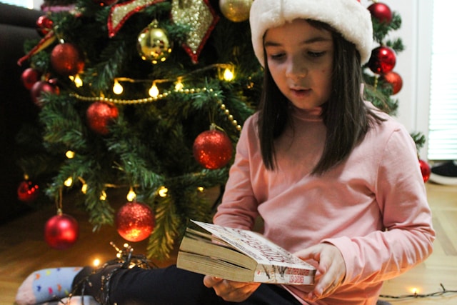 une-petite-fille-assise-par-terre-en-train-de-lire-un-livre